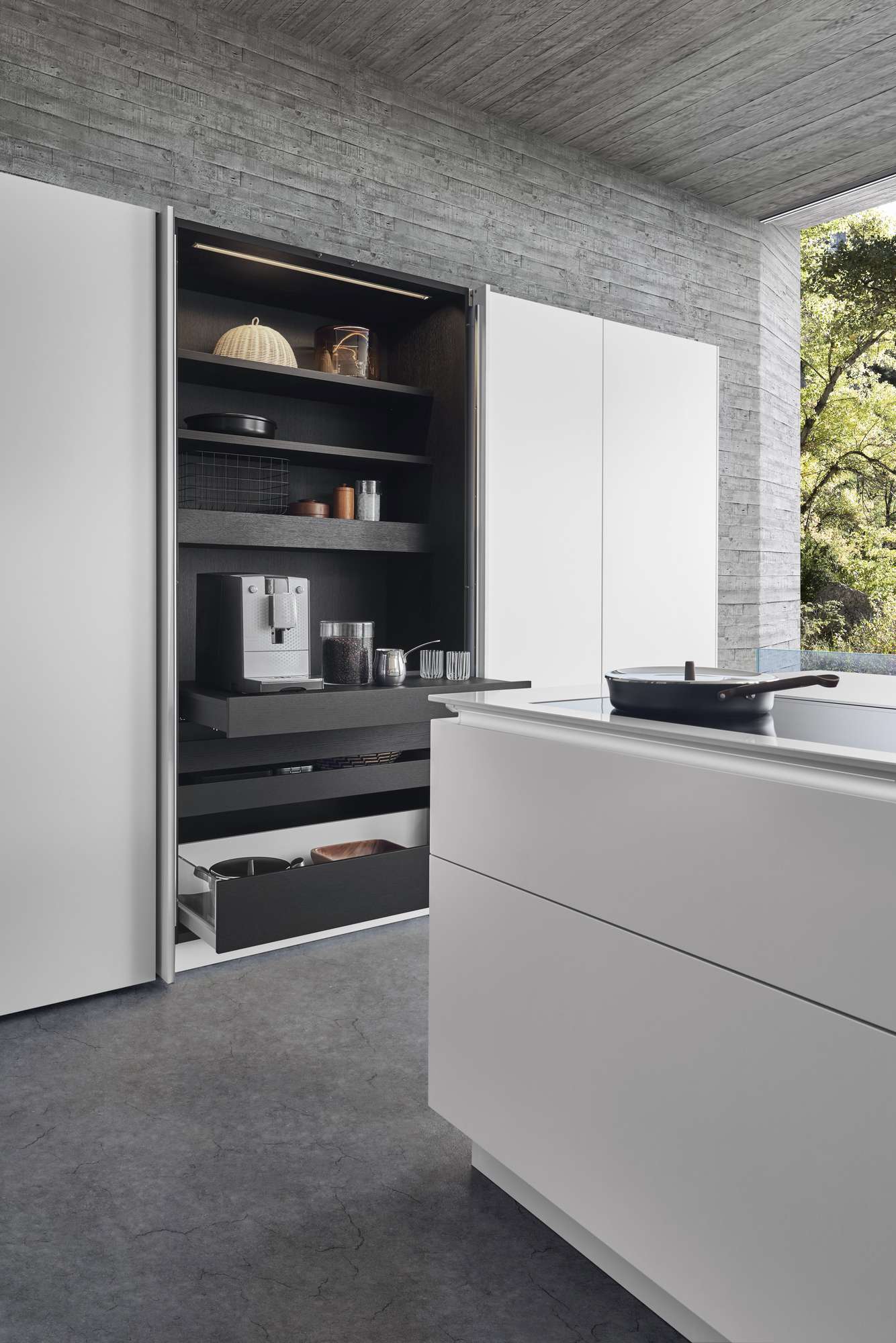 Geöffneter Einschubtürenschrank mit Kaffeemaschine in der LEICHT Design Inselküche Classic-FS-C mit Raumteiler