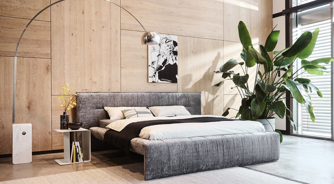 Möller Design Bett FLAP mit gepolstertem Kopfteil in einem Loft mit Holzwand