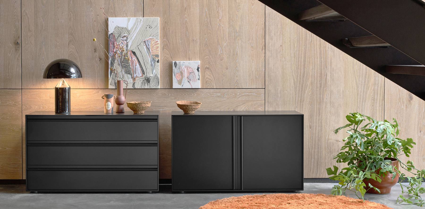 Möller Design Kommoden GRIPPY mit Griffleisten vor einer Holzwand