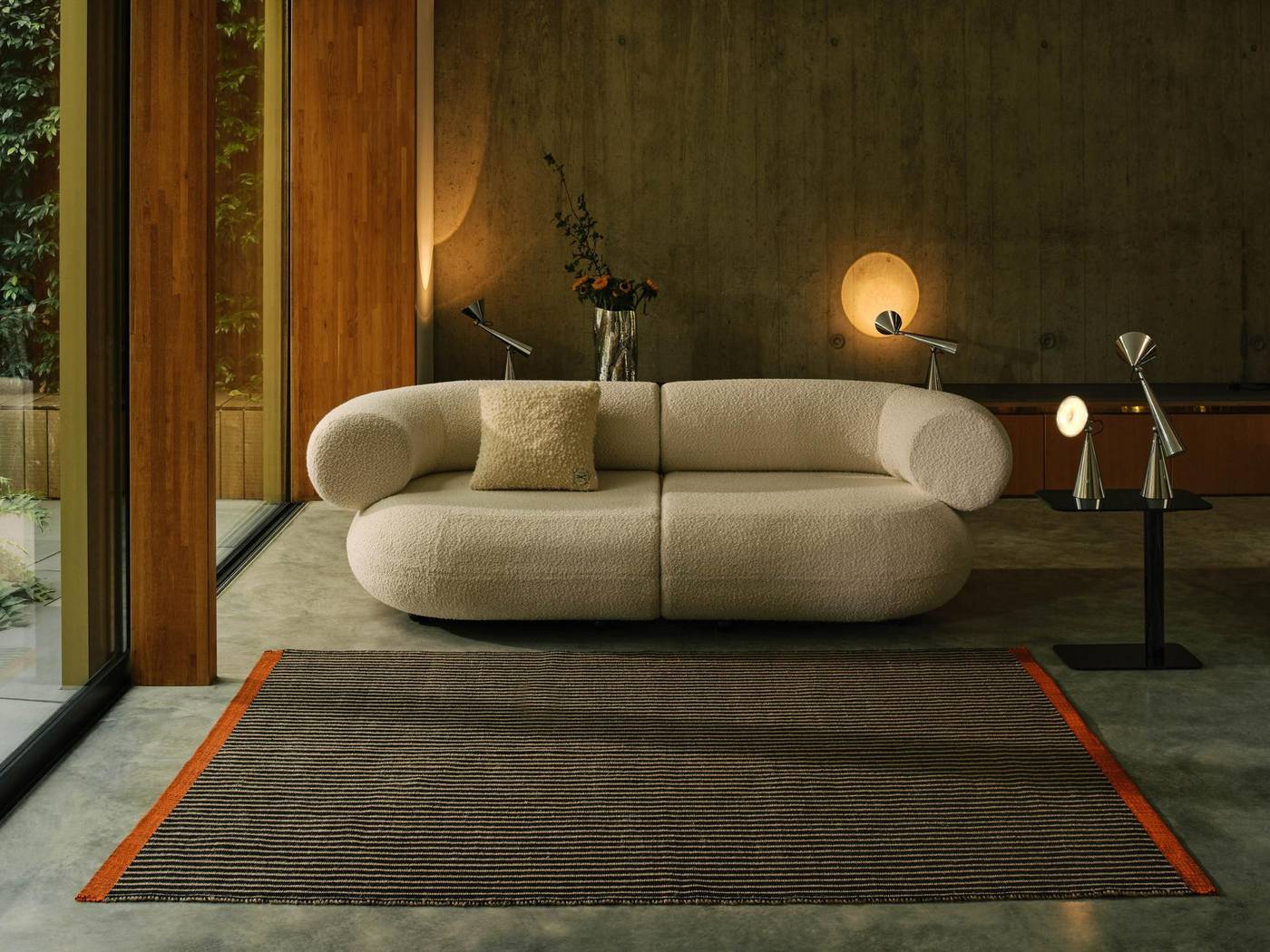 Tom Dixon Wohnraum mit Sofa und Leuchten am Abend